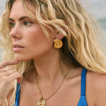 Model in gold fill shell shaped stud earrings