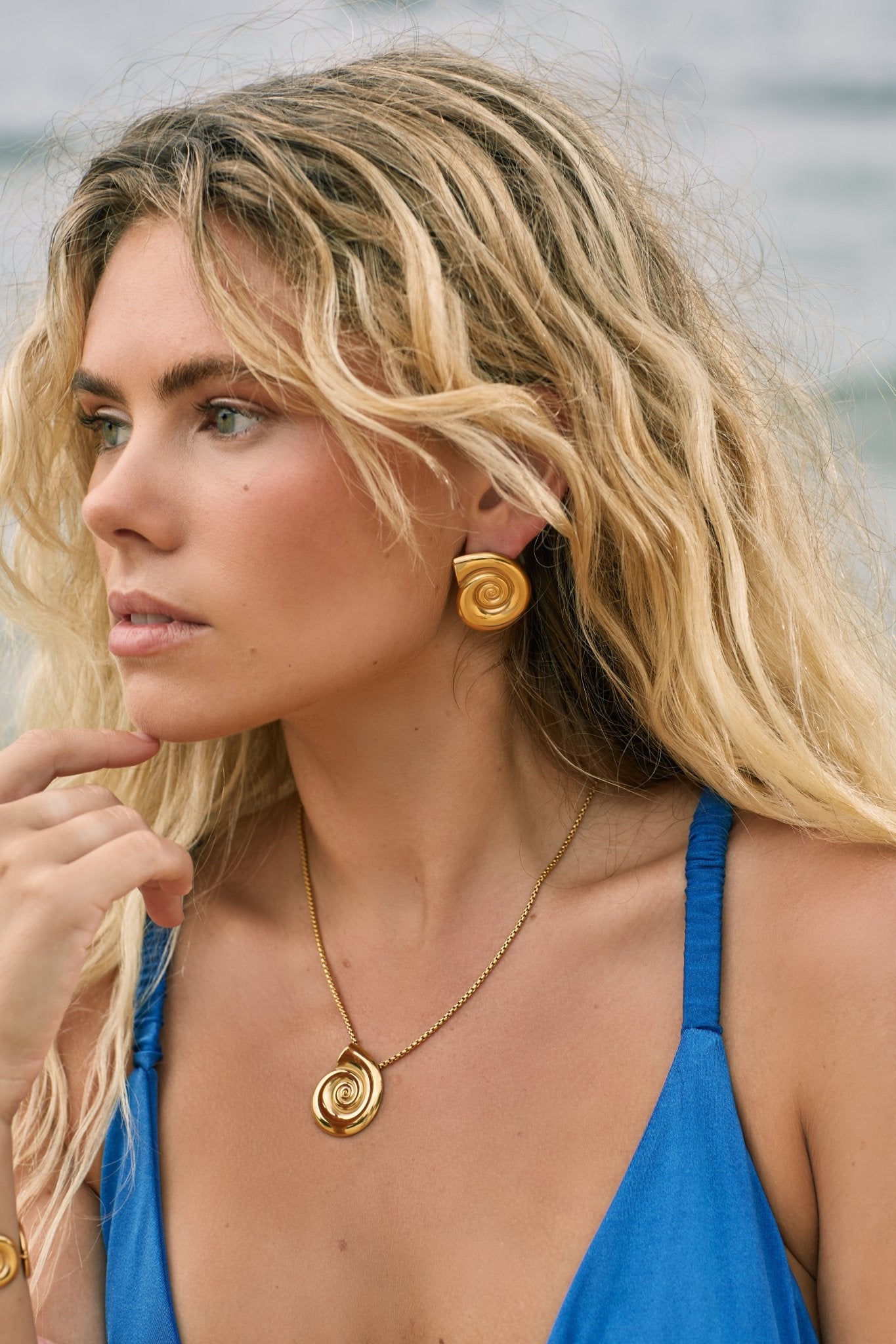 Model in gold fill shell shaped stud earrings