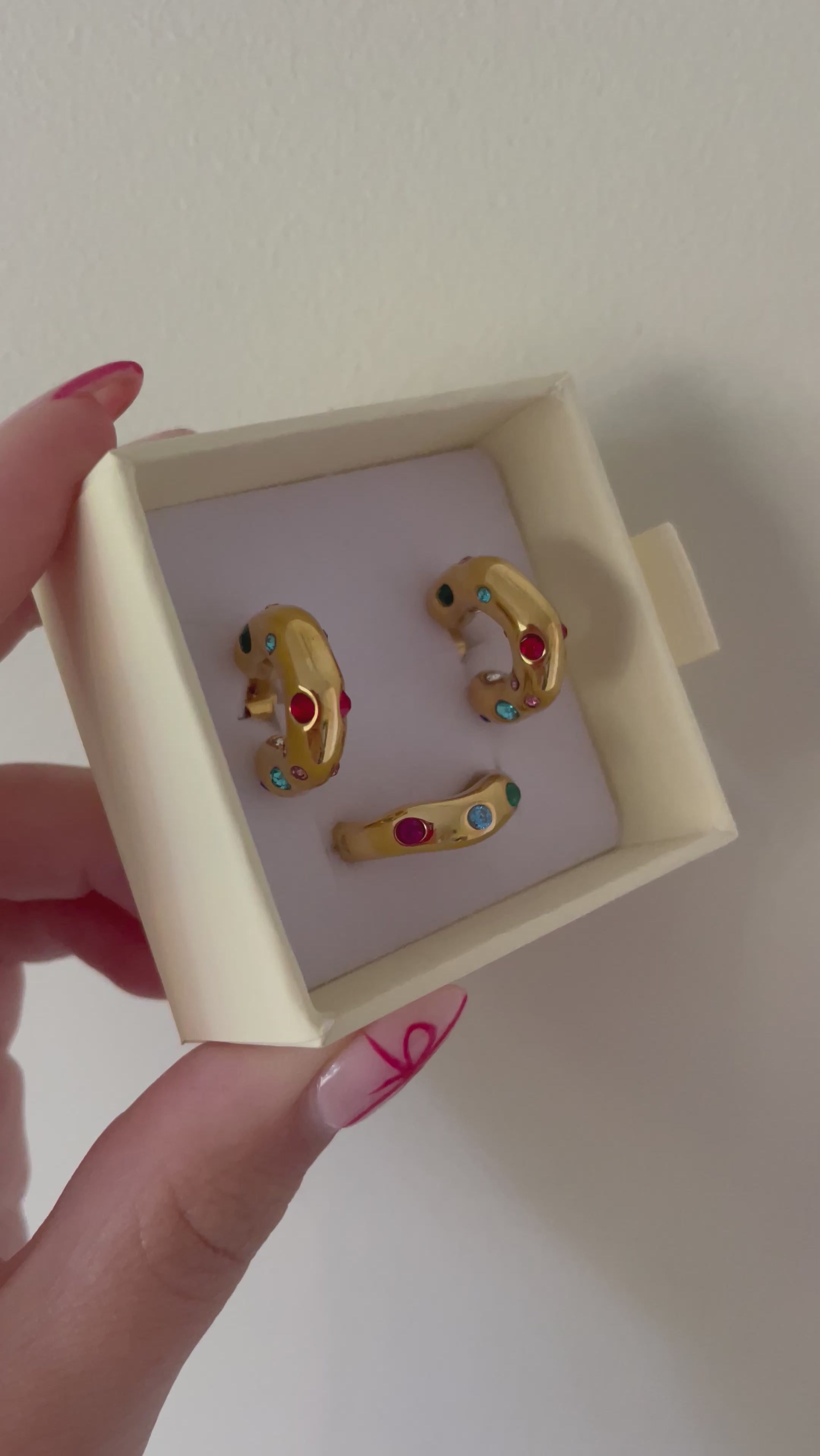 Video of Bixby packaging with multicoloured gemstone ring and earrings in gold